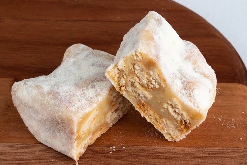 dois pedaços de palha italiana de leite em pó cortados em uma tábua de madeira - Assaí Atacadista - doces para vender no verão