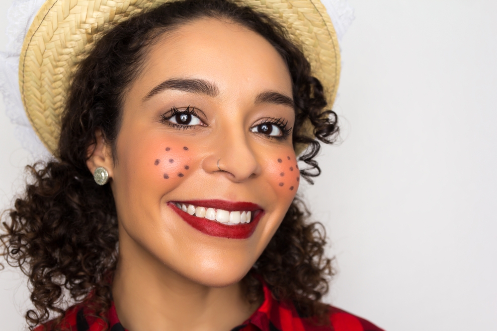 mulher negra jovem feliz com maquiagem de São João - serviços temáticos - Assaí Atacadista