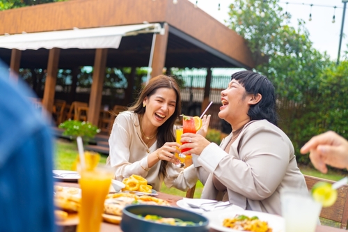 mulheres asiáticas felizes com copos de suco na mão - bebidas de verão - Assaí Atacadista