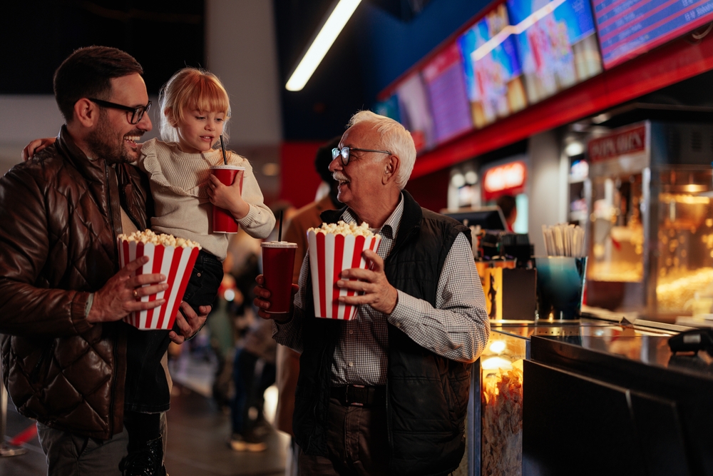 pai, criança e avô brancos felizes em um cinema com pipocas - presentes para pais - Assaí Atacadista