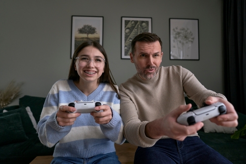 pai e filha brancos jogando videogame na sala - Assaí Atacadista - atividades familiares