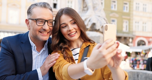 pai e filha tirando uma selfie em um ponto turístico - atividades familiares - Assaí Atacadista