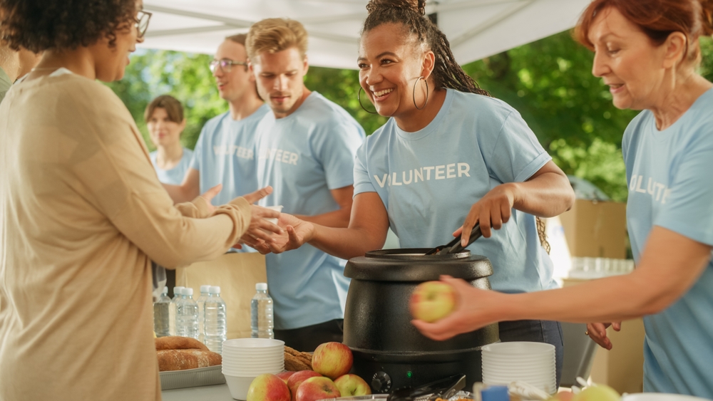 pessoas diversas participando de um evento como voluntários - hábitos para praticar - Assaí Atacadista