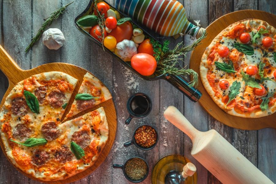 mesa com pizza e temperos - abrir uma pizzaria - Assaí Atacadista