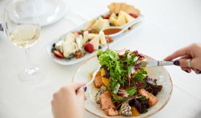 mãos brancas femininas segurando talheres com um prato de salada chique - Assaí Atacadista - Saladas chiques