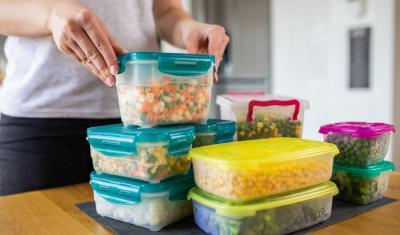 mãos brancas segurando potes empilhados com comida pronta - Assaí Atacadista