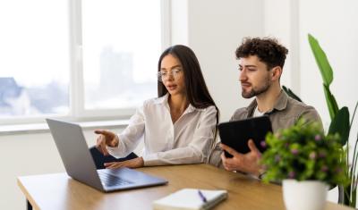 mulher e homem brancos jovens concentrados olhando para um notebook - período de experiência - Assaí Atacadista